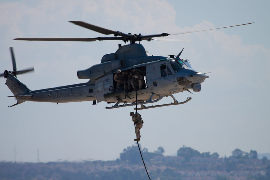 Collection of helicopter insertion and extraction gear, including fast ropes, SPIE ropes, rappel belts, gloves, descenders, and storage bags, displayed with tactical and military equipment for safe and efficient operations.