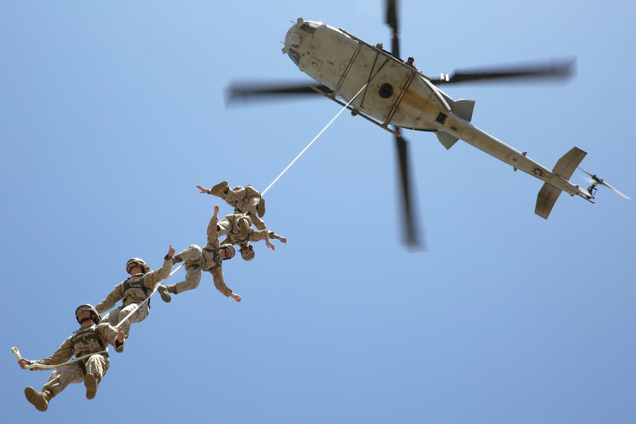 U.S. Marines suspended on a SPIE rope under a helicopter, demonstrating a fast and efficient extraction operation in action. (8745383624941)